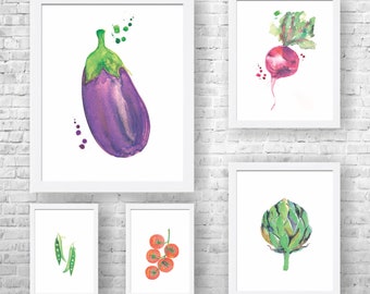 May include: Five watercolor paintings of different vegetables framed in white frames. The paintings are of an eggplant, a radish, an artichoke, peas, and tomatoes.