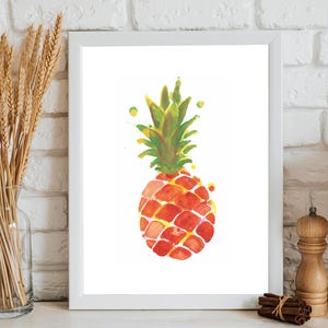 May include: A framed watercolor print of a pineapple. The pineapple is depicted in shades of red, orange, and yellow, with a green crown. The artwork is displayed in a white frame, suitable for kitchen or dining room decor.