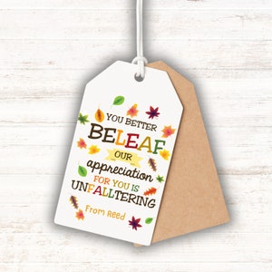 May include: White gift tag with brown paper backing. The tag has a fall-themed design with colorful leaves and the text "You better beleaf our appreciation for you is unfaltering. From Reed."