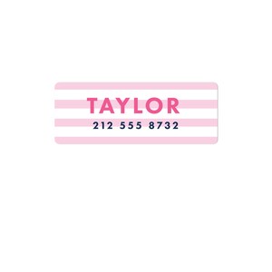 May include: Pink and white striped label with the name "TAYLOR" in pink letters and the phone number "212 555 8732" in blue letters.
