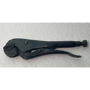 May include: A black metal pipe wrench with a silver adjustment screw. The wrench has the text "Wilton - Bench" and "PAT. PEND." on the handle.