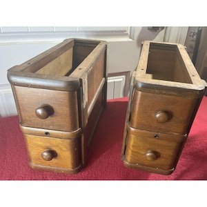 May include: Two wooden drawer units with two drawers each. The drawers are unfinished and have a natural wood color. The units are made of solid wood and have a simple, classic design.