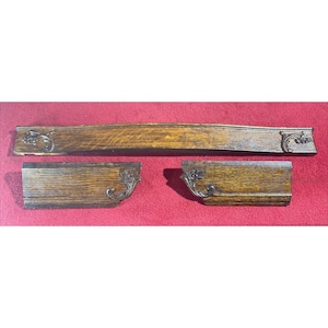 May include: Three pieces of wood trim with ornate carvings. The top piece is curved and the two bottom pieces are straight. The wood is a dark brown color.