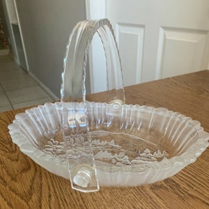May include: A clear glass bowl with a frosted finish and a decorative etched design. The bowl has a clear plastic handle.