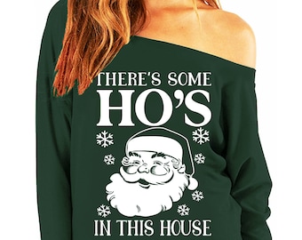 May include: Green off-the-shoulder sweatshirt with a white graphic of Santa Claus and the text "There's some HO'S in this house".