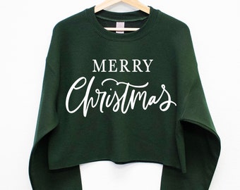 May include: A dark green cropped sweatshirt with the text "Merry Christmas" in white lettering.