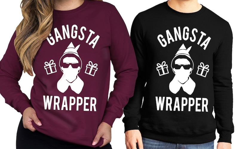 May include: Two long-sleeved sweatshirts with a white graphic of a person wearing a Santa hat and sunglasses with the text "Gangsta Wrapper". The sweatshirt on the left is maroon and the sweatshirt on the right is black.