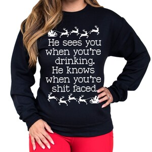 May include: Black Christmas sweater with white text that reads "He sees you when you're drinking. He knows when you're shit faced."  The sweater features a repeating pattern of Santa Claus in a sleigh pulled by reindeer.