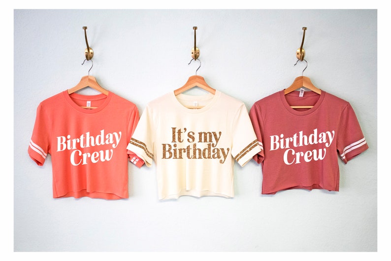 May include: Three cropped t-shirts with white text on different colored shirts. The shirts have gold glitter accents on the sleeves. The text on the shirts reads "Birthday Crew", "It's my Birthday", and "Birthday Crew".