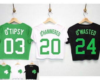 May include: Three green, white, and black crop tops with shamrock designs and the text "O'Tipsy 03", "O'Hammered 20", and "O'Wasted 24" printed on the back.