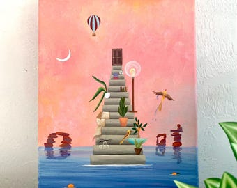May include: A rectangular canvas painting depicts a stone staircase rising from blue water against a pink sky. The stairs feature a door at the top, a lamp, potted plants, a bird, and a blanket. A hot air balloon and crescent moon float above.