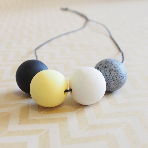 Black, yellow, white and granite polymer clay necklace on black cord