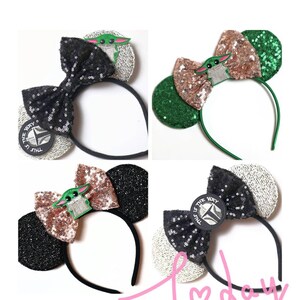 May include: Three pairs of black and silver sequined Minnie Mouse ears with a green and gold bow and a character from the Star Wars series, The Mandalorian, with the text "This is the way".