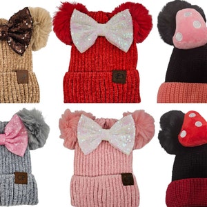 May include: Six different knit hats with pom-poms and bows. The hats are in various colors, including beige, red, black, gray, pink, and a combination of red and black. The bows are made of sequins, felt, and polka dot fabric.