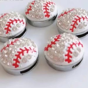 May include: Five white baseball charms with red stitching and rhinestones. The charms are silver-toned and have a flat back.