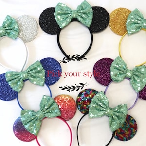 May include: A set of eight headband ears with a variety of colors and glitter. Each headband has a green bow. The headband ears are made of felt and sequins. The text "Pick your style" is visible in the center of the image.
