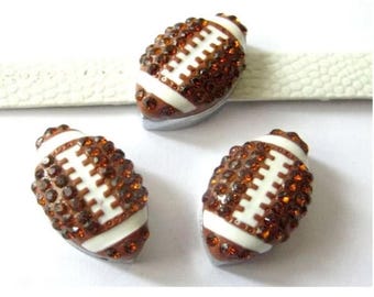 May include: Three brown and white football-shaped charms with rhinestones. The charms are approximately 1 inch long and are perfect for adding a sporty touch to jewelry or crafts.