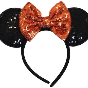 May include: Black mouse ears headband with a large orange sequin bow.