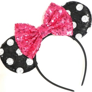 May include: Black and white polka dot mouse ears headband with a pink sequined bow.