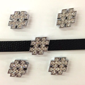 May include: A black choker necklace with a silver hashtag-shaped pendant encrusted with clear rhinestones. Four additional hashtag-shaped embellishments with rhinestones are also present, likely for other jewelry or craft projects.