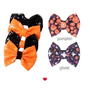 Può includere: Fiocchi per capelli a tema Halloween. Tre fiocchi con paillettes arancioni e centri neri. Due fiocchi fantasia: uno con grafica di zucche e la parola "pumpkin", e un altro con grafica di fantasmi e la parola "ghost".