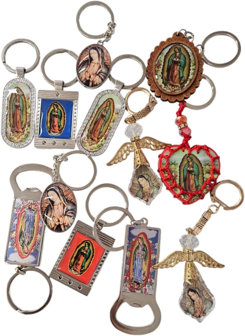 May include: A collection of religious keychains featuring images of the Virgin Mary. The keychains vary in shape and design, including oval, rectangular, and heart-shaped pendants. Some have decorative accents like rhinestones and angel wings.