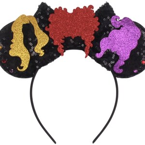 May include: Black headband with three colorful felt ears. The ears are shaped like the Sanderson sisters from the movie Hocus Pocus. The ears are decorated with glitter and sequins.