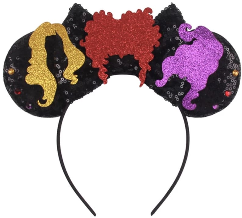 May include: Black headband with three colorful felt ears. The ears are shaped like the Sanderson sisters from the movie Hocus Pocus. The ears are decorated with glitter and sequins.