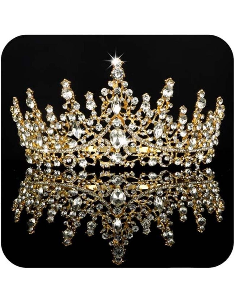 Pode incluir: Uma coroa dourada com numerosos cristais claros e brilhantes. A coroa tem um design ornamentado e sim&eacute;trico, com uma superf&iacute;cie refletora por baixo, sobre um fundo preto.