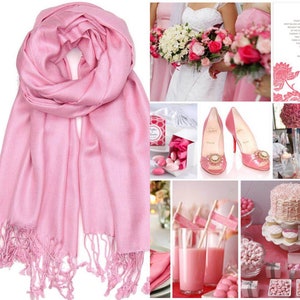 May include: A pink pashmina scarf with fringe. The scarf is folded in half and draped over a white background. The image also includes a collage of pink wedding decorations, including flowers, shoes, and desserts.