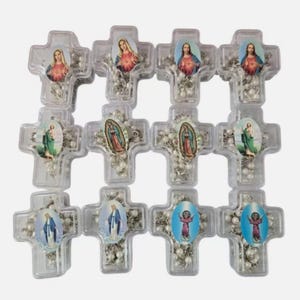 May include: A collection of clear plastic cross-shaped rosaries. Each cross features a religious image and a string of white beads. The images include depictions of religious figures in various colors.