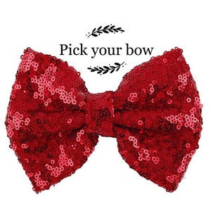 May include: A red sequined bow with the text "Pick your bow" above it.