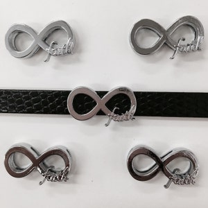 May include: Five silver infinity symbol charms with the word "faith" inscribed on each charm. The charms are displayed on a black leather strap.
