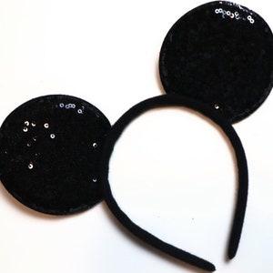 May include: Black headband with two black sequined ears shaped like Mickey Mouse ears.