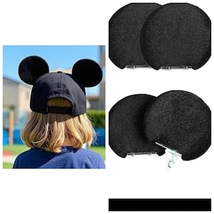 Puede incluir: Gorra de béisbol negra con orejas grandes y redondas. La gorra la lleva una persona con cabello rubio. También se muestran dos pares de accesorios para las orejas redondas negras con clips metálicos.