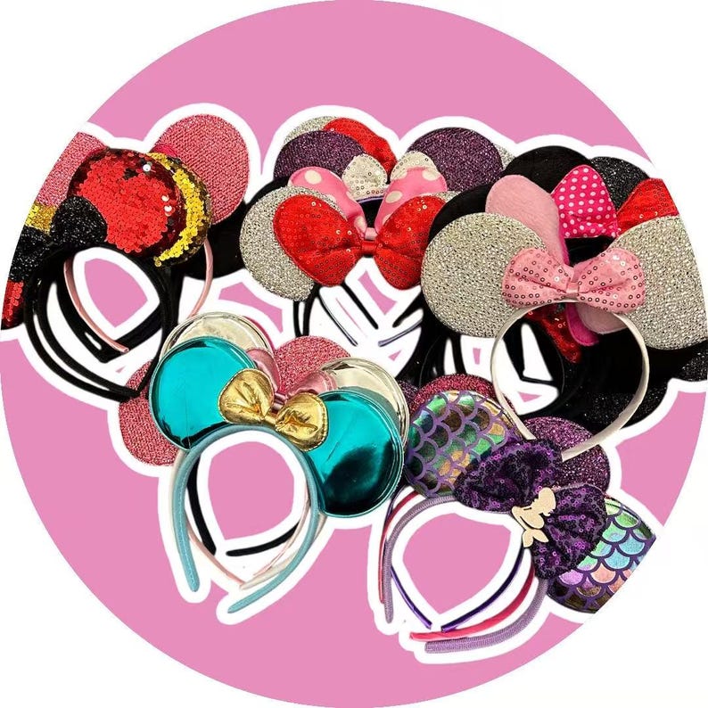 May include: A collection of decorative headbands with various designs. The headbands feature mouse ears in a variety of colors, including red, pink, silver, and teal. Some headbands have bows, sequins, and glitter accents. The headbands are on a pink background.