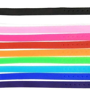 May include: A collection of colorful silicone wristbands in various shades, including black, white, pink, red, orange, green, blue, and purple. Each band features a silver-colored buckle for secure fastening. These bands are suitable for everyday wear.