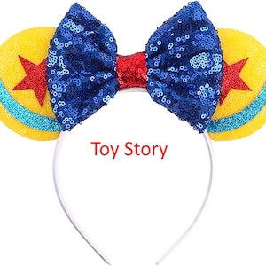 May include: Blue and yellow sequined headband with a red bow and a white headband. The headband features a yellow and blue star design. The text "Toy Story" is printed on the headband.
