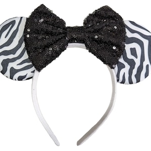 May include: Black and white zebra print headband with a black sequined bow.