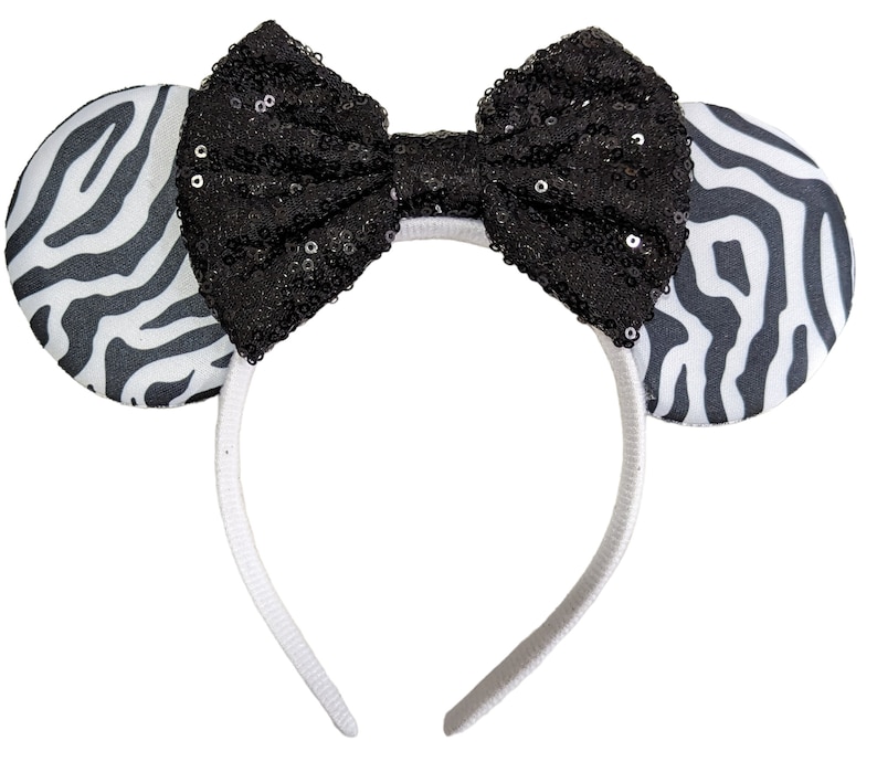 May include: Black and white zebra print headband with a black sequined bow.