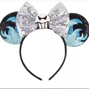 May include: Black headband with blue and silver sequined ears. The ears feature a white and black character with a ghost-like face.