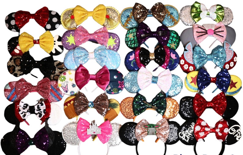 May include: A collection of 20 colorful, sparkly Minnie Mouse ears headbands. Each headband features a different design, including characters from popular movies and TV shows.