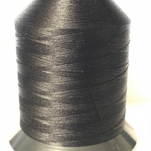 May include: A spool of black thread for sewing or embroidery.