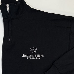 May include: Black mock neck sweatshirt with a white embroidered logo that says "Melissa, BSN RN Orthopedics".