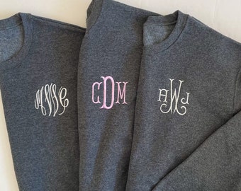 May include: Three gray sweatshirts with embroidered monograms. The monograms are "AWS", "CDM", and "HWJ".