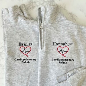 May include: Two gray sweatshirts with a heart and EKG graphic, the text "Cardiopulmonary Rehab" and the names "Erin, EP" and "Hannah, EP" embroidered on the front.