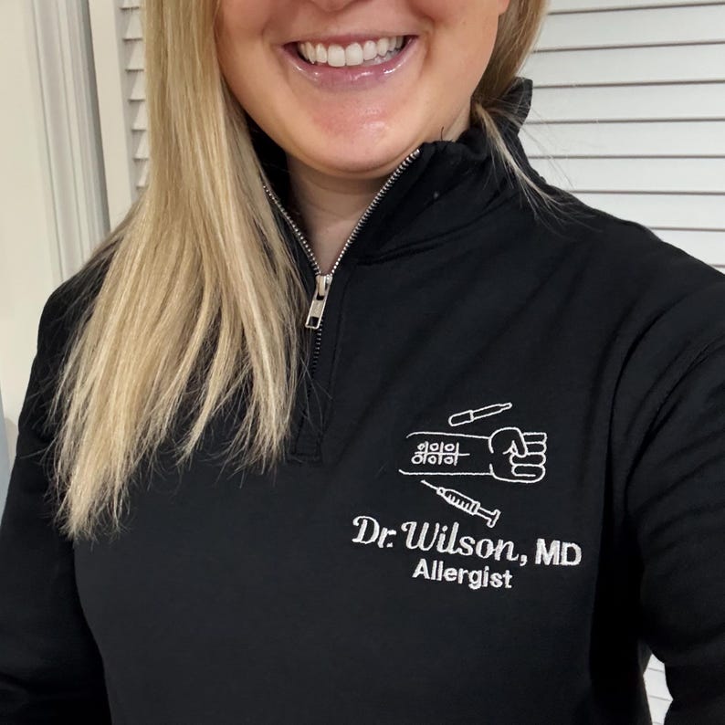 Unisex quarter zip sweatshirt for allergy and immunology medical professionals, available in sizes S-3XL. Features embroidered name, credentials, job title, or department. Design showcases an allergy test on an arm. Comfortable and professional—perfect for clinics, hospitals, or everyday wear. Makes a unique personalized gift for allergy doctors, nurses, or medical staff.