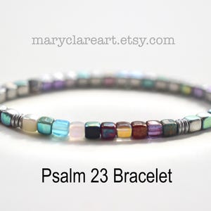 May include: A colorful bracelet with square beads in various colors, including blue, green, purple, and red. The bracelet is labeled "Psalm 23 Bracelet" and has the website maryclareart.etsy.com in the image.