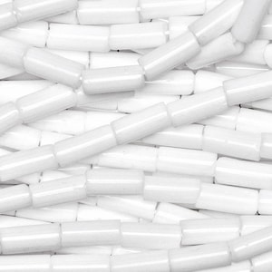 May include: A close-up of a pile of white glass beads. The beads are cylindrical in shape and have a smooth, glossy finish.