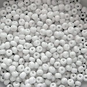 May include: A large quantity of white seed beads. The beads are small and round, with a hole in the center. They are perfect for crafting and jewelry making.